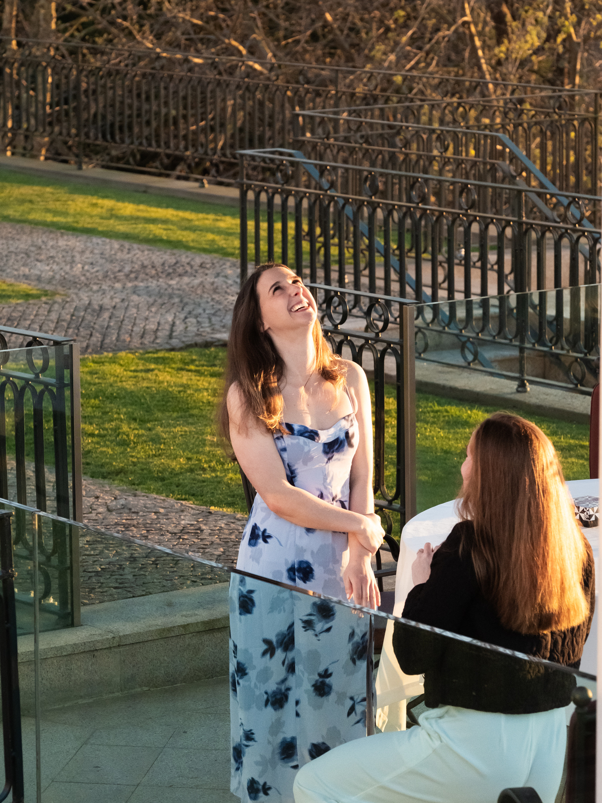 Claire kneels before Julia, holding a ring, with the sunset glowing behind them