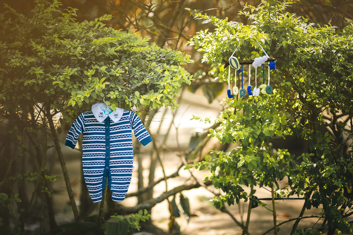 Roupinha na árvore em ensaio de gestante