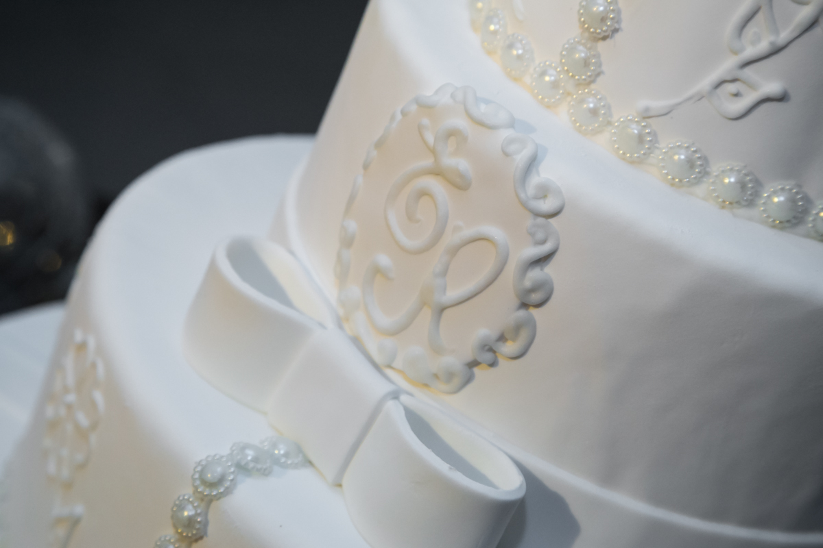 Bolo branco com brasão  dos noivos