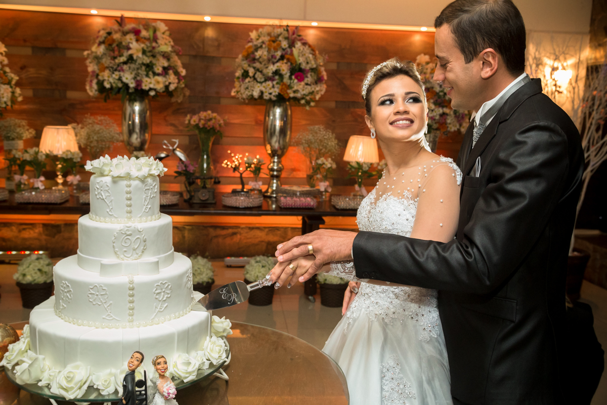 Noivos cortando bolo em casa lounge 