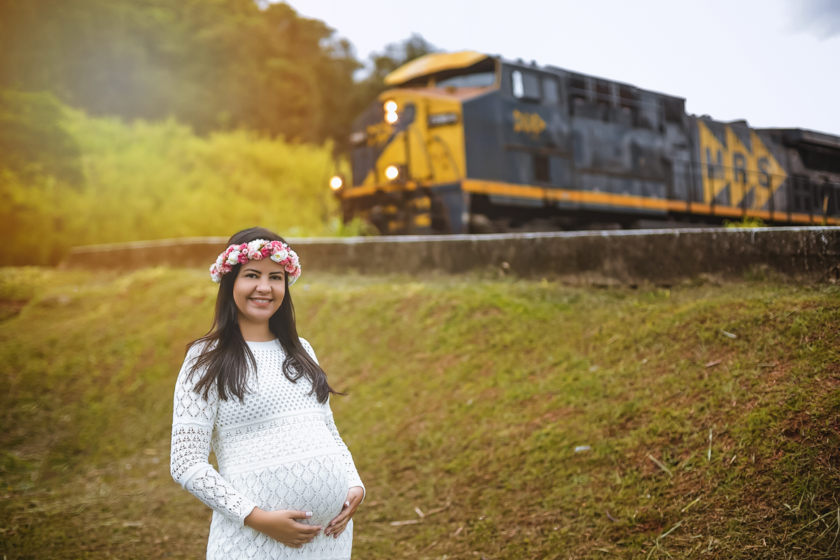 Ensaio de gravida com enfeite rosas na cabeça na linha do trem