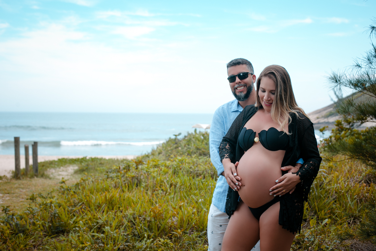 Ensaio gestante sorrindo junto com marido em grumari 