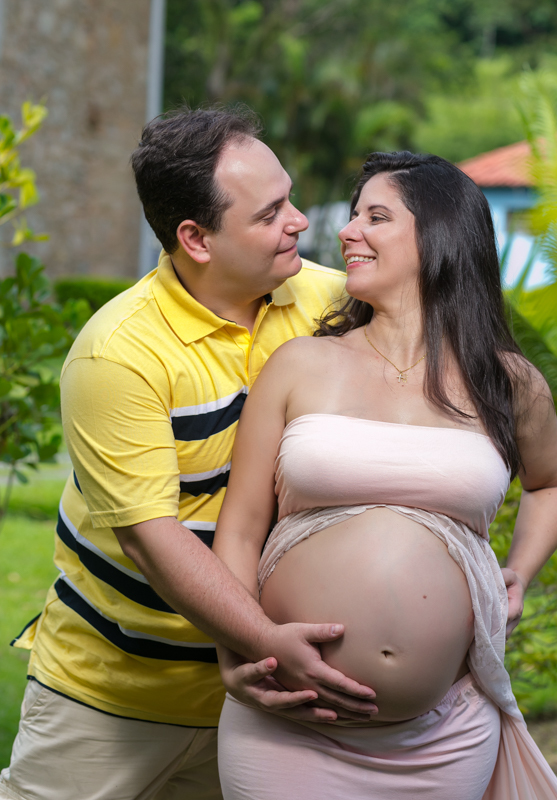 Ensaio gestante junto com esposo ele a abraçando ela sorrindo