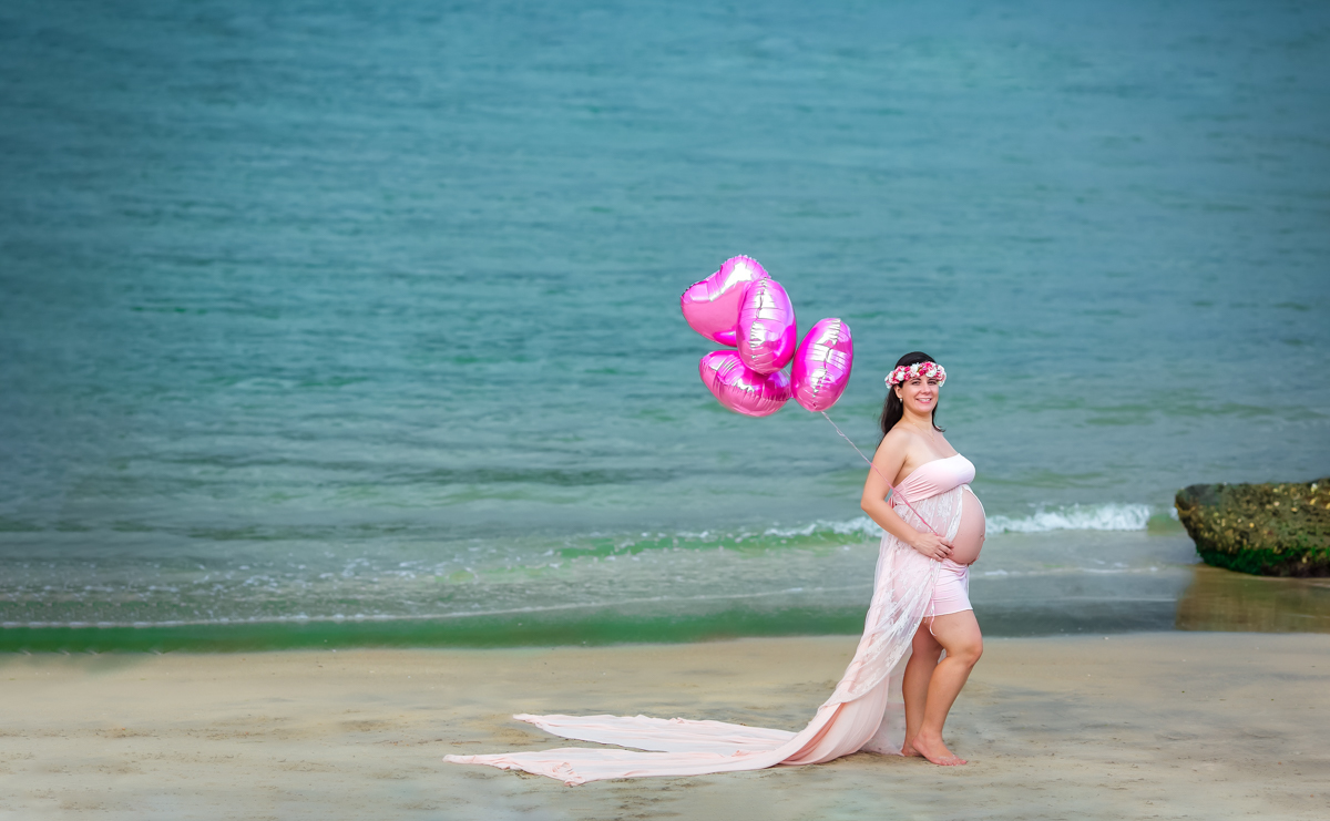 Ensaio de gestante na praia com vestido e balões rosa