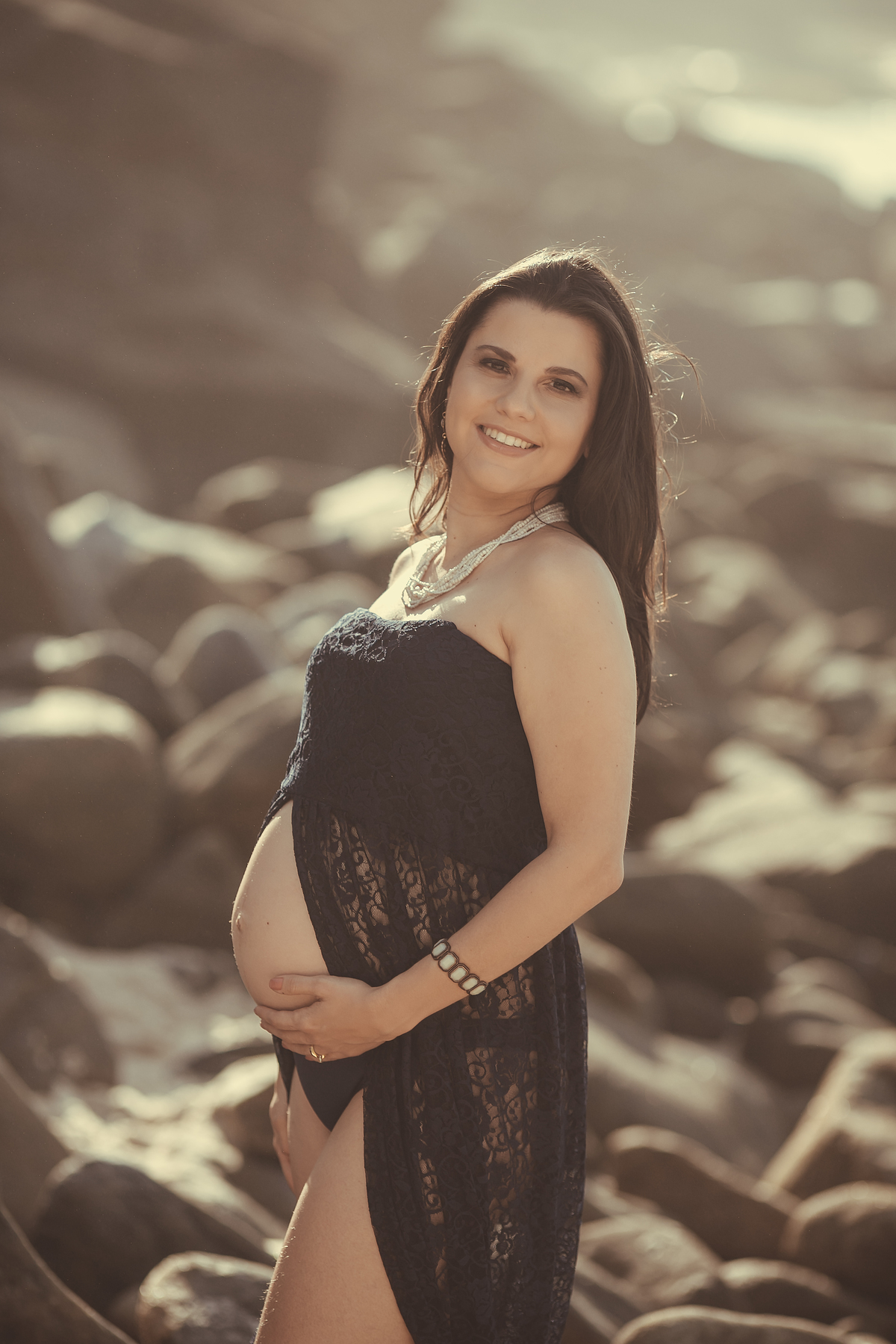 Ensaio gestacional em praia com vestido de renda