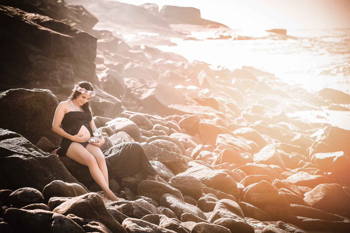 Gestante sentada sobre pedra na prainha RJ
