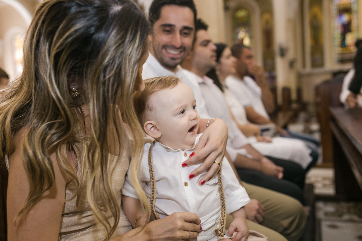 Criança bocejando aguardando em seu batizado na Paróquia  São Paulo