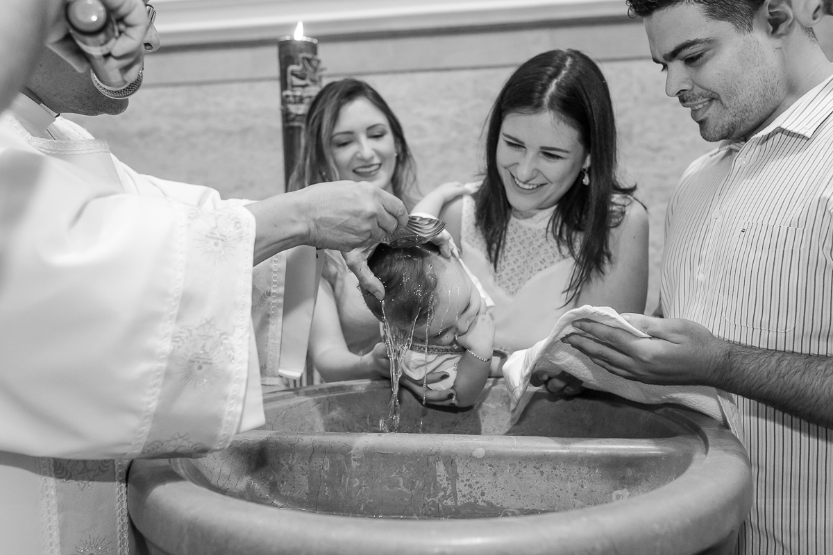 Água benta na cabeça da criança em batizado  na Paroquia  São Paulo Apostolo 