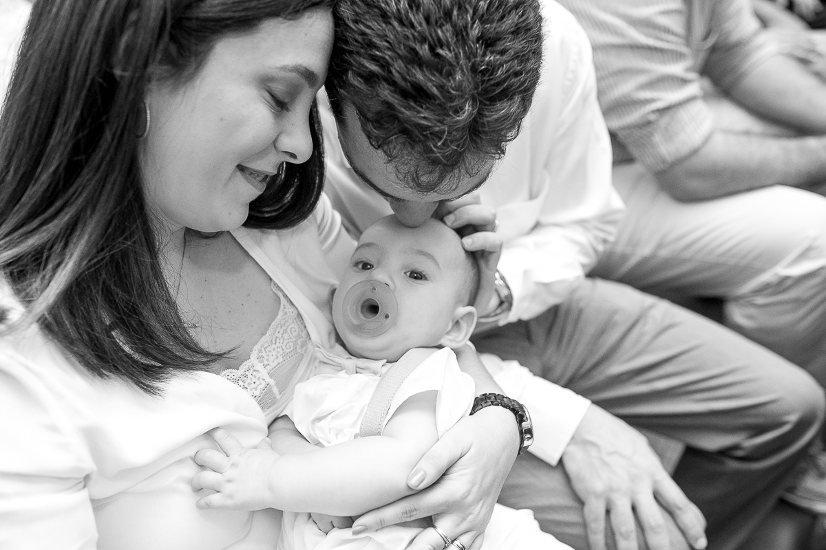 Fotografia de família pai beijando cabeça de filho  em seu batizado na  Paróquia São Paulo Apóstolo RJ