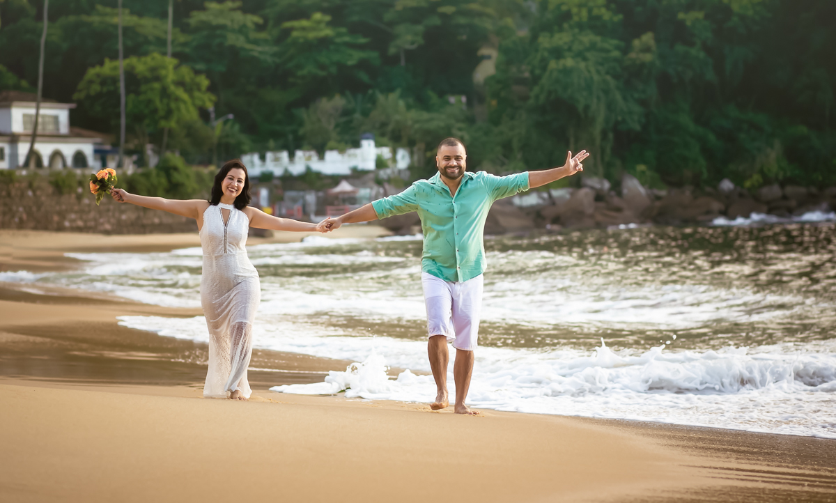 Ensaio PRÉ CASAMENTO casal caminhando na praia de braços abertos 