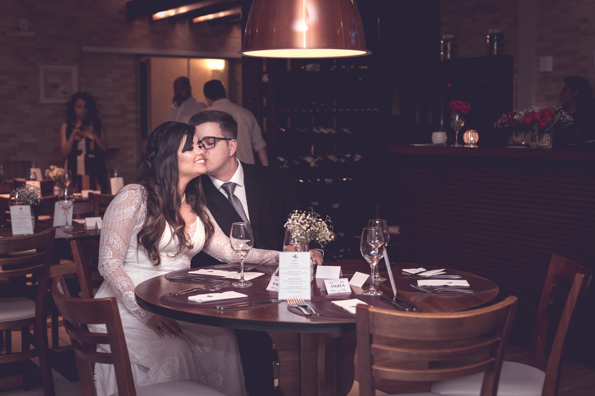 Casal de noivos em sua festa de casamento, noivo da um beijo em rosto da noiva  MANJERONA CANTINA & PIZZARIA
