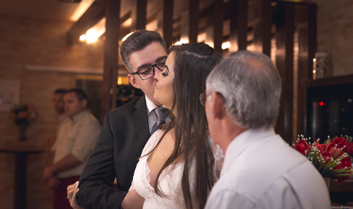 Beijo do noivo em rosto da noiva em 