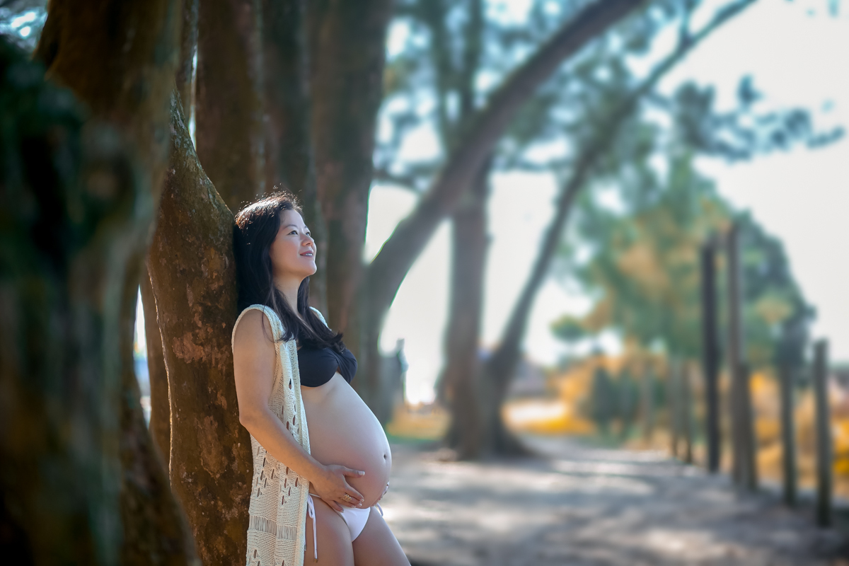 Gestante encostada na árvore em ensaio gestante no Grumari-RJ