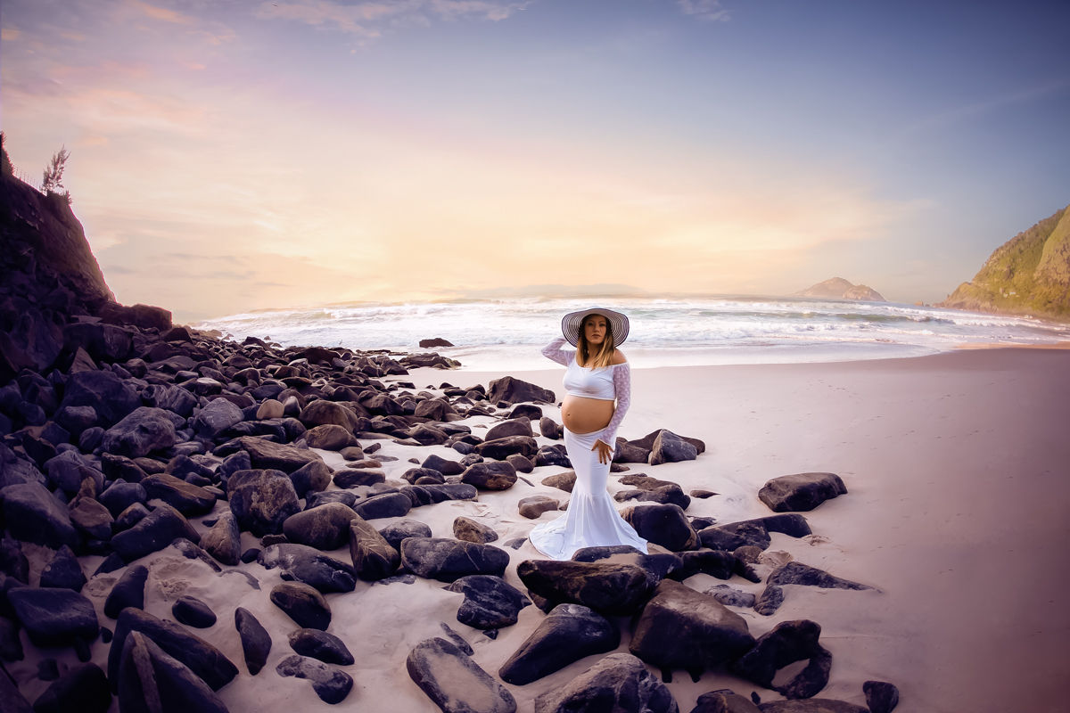 Gestantes com chapéu em cima das pedras em ensaio fotográfico/Grumari