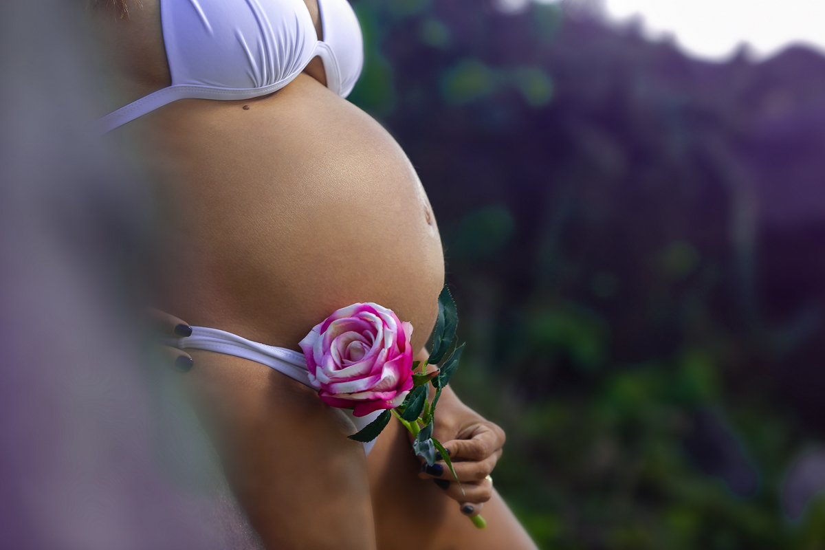 Gestante usando rosa  na barriga em ensaio em Grumari/RJ