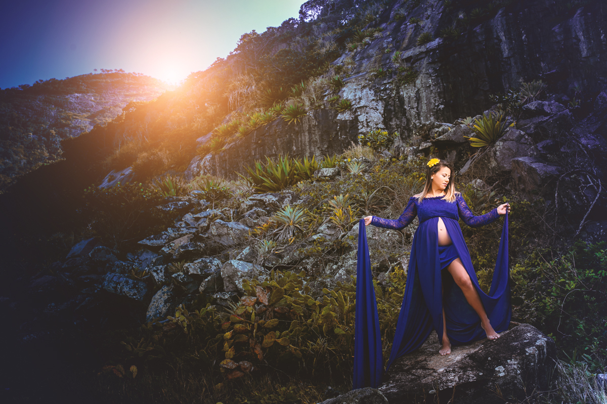 Gestante sobre as pedras ao fundo por do sol na Prainha/RJ