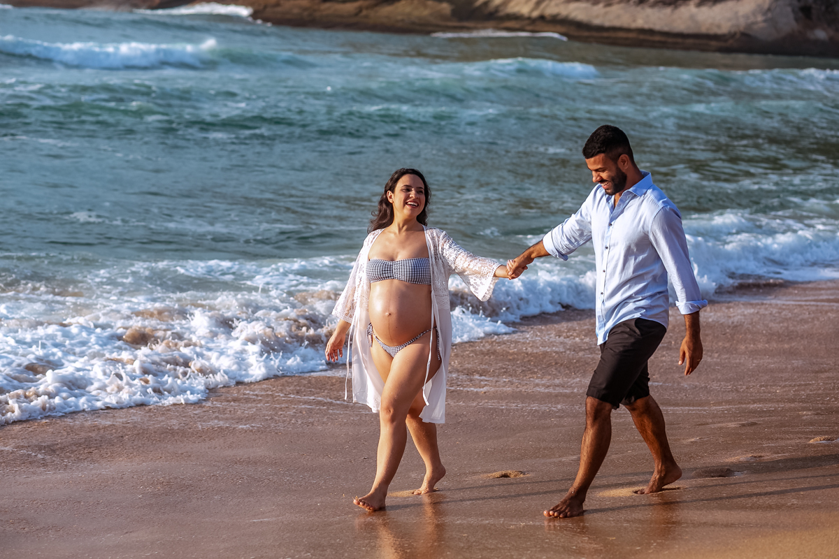 Caminhada de gestante e seu esposo em praia ensaio externo/Grumari