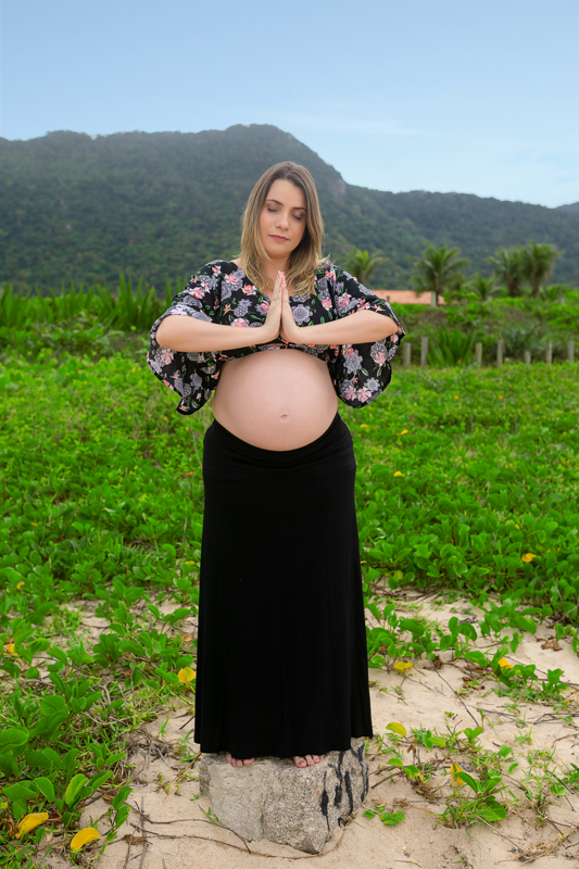 Ensaio  fotográfico externo de gestante ela fazendo oração em para de praia de Grumari-RJ
