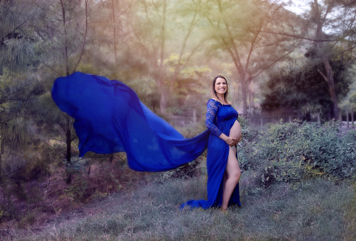 Vestido com calda esvoaçante azul em ensaio gestante externo Grumari/RJ