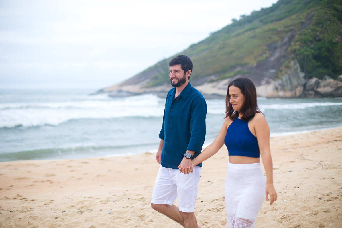 Casal caminhando de mãos dadas em praia de Grumari, Pré-Casamento