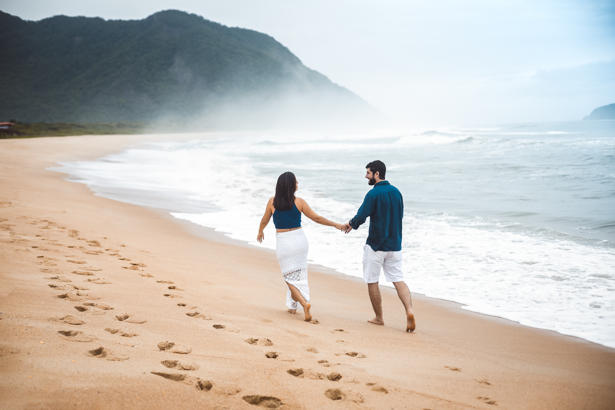 Noivos caminhando em ensaio casal em Praia de Grumari/RJ