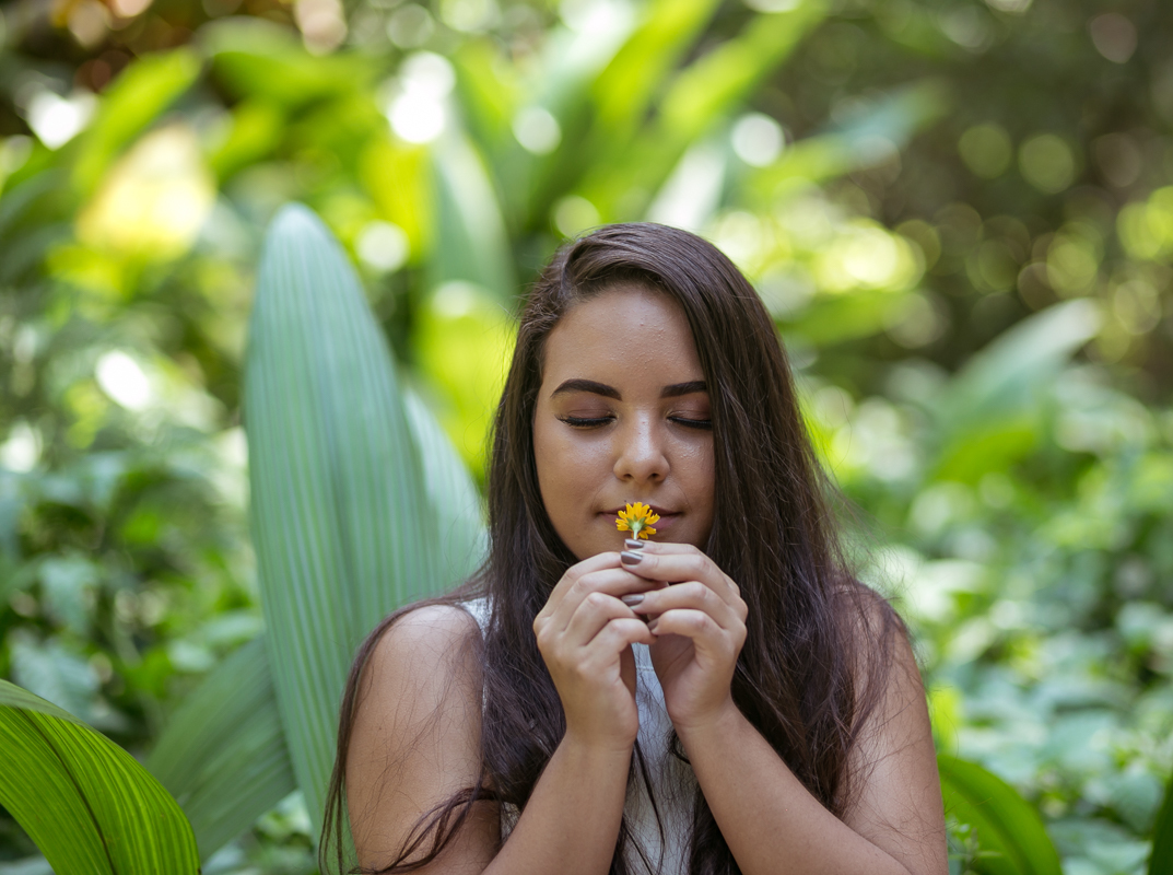 Debutante cheirando florzinha em seu ensaio de Debutante