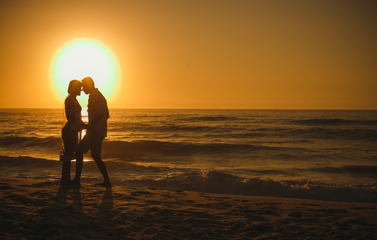 Casal em book fotográfico comemorando suas bodas em lindo ensaio ao nascer do sol/prainha