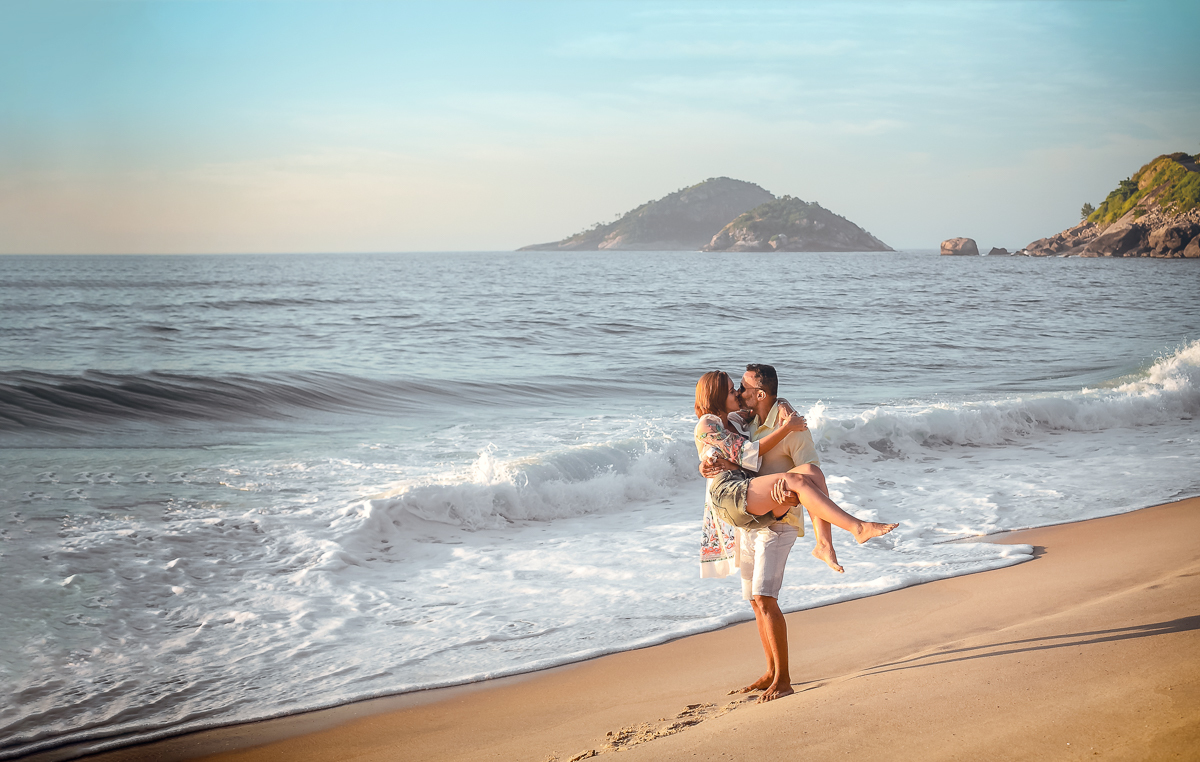 Casal brincando na areia em seu ensaio fotográfico em Prainha/RJ