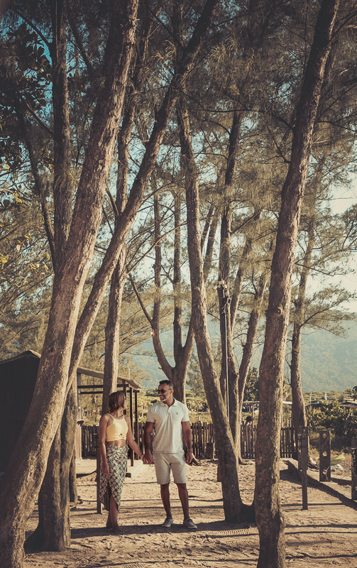 Casal entre as árvores em seu ensaio fotográfico em Grumari/Rj
