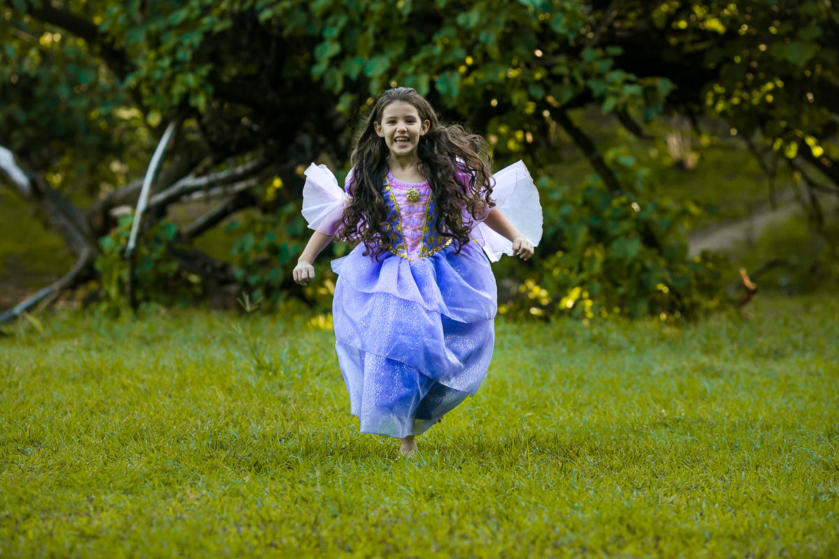Clarissa correndo com vestido da princesa Rapuzel em seu ensaio temático na Quinta da Boa Vista/RJ