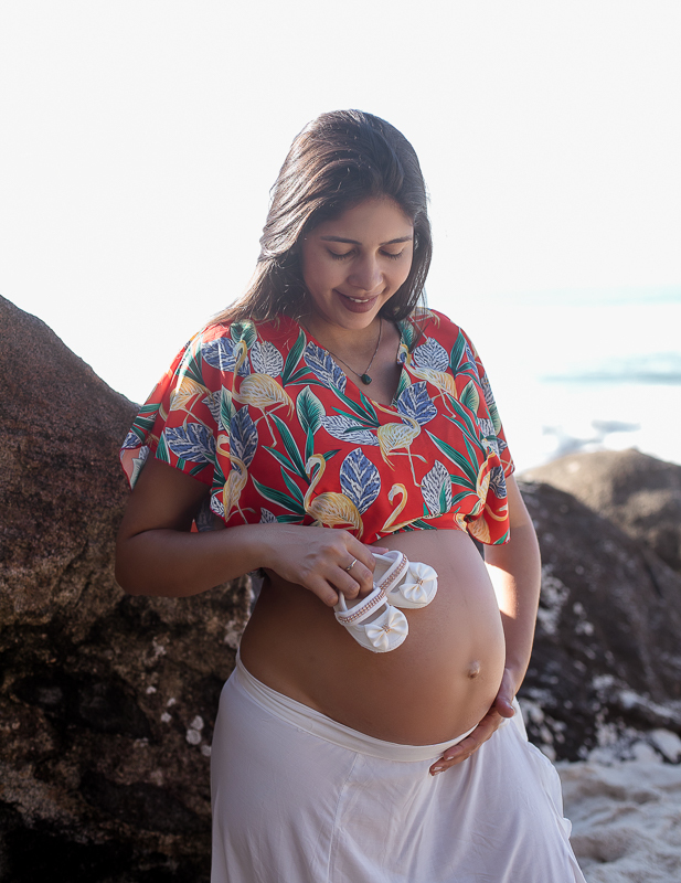 Gestante em ensaio externo apoiando sapatinho