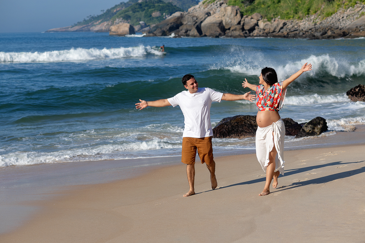 Caminhando  junto com esposo na areia em ensaio de gestante na prainha/RJ
