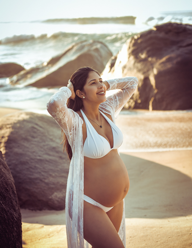 Fotografia de gestante em ensaio na prainha  ao fundo mar-RJ