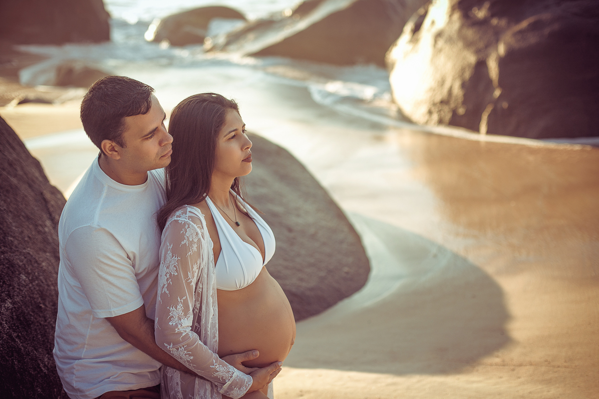 esposo segurando a barriga da gestante em ensaio na prainha/RJ