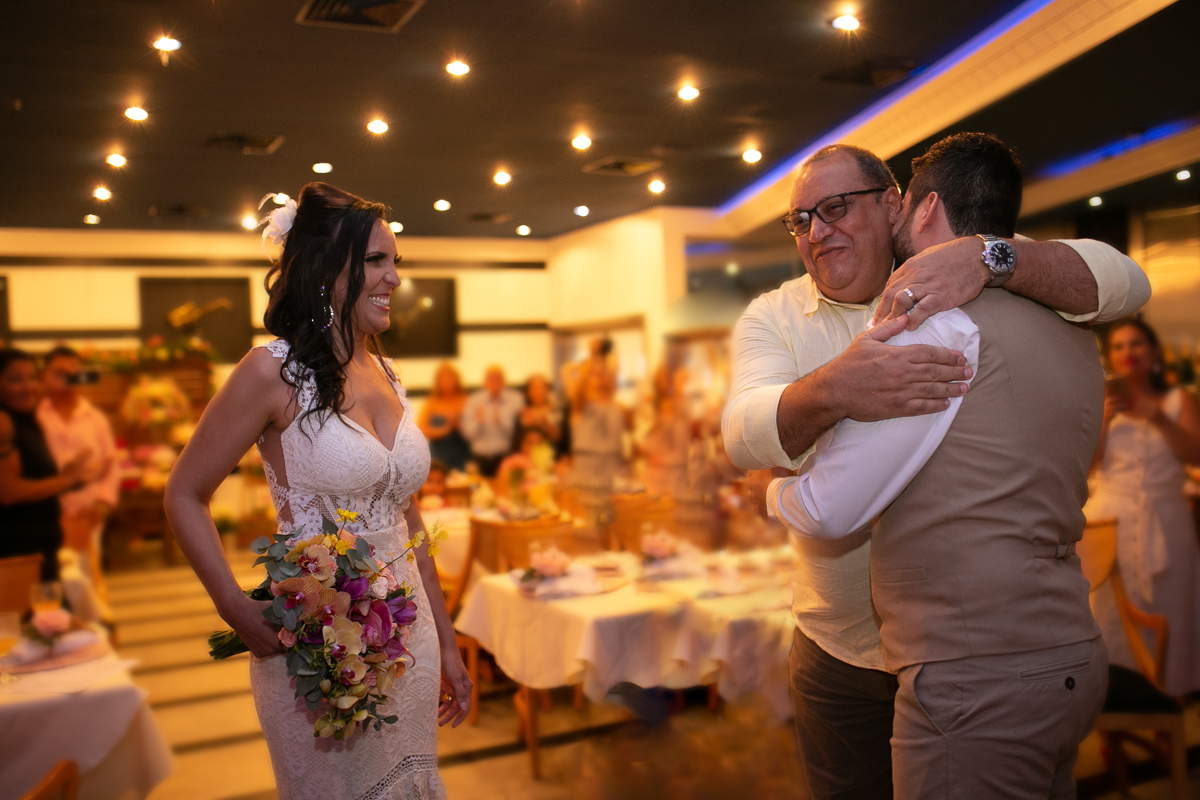 Pai da noiva abraçando noivo  na cerimônia casamento