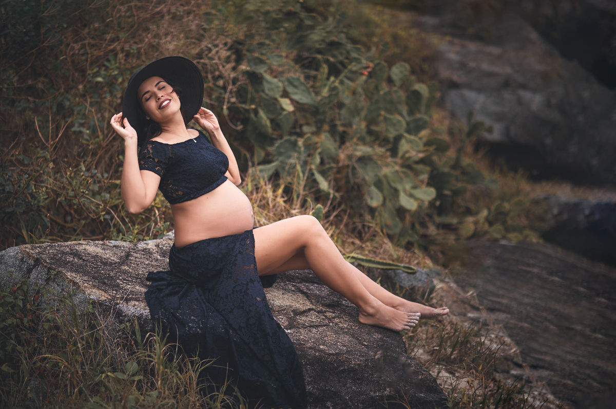 gestante fazendo pode com roupa de renda e chapéu em seu ensaio fotográfico externo-rj