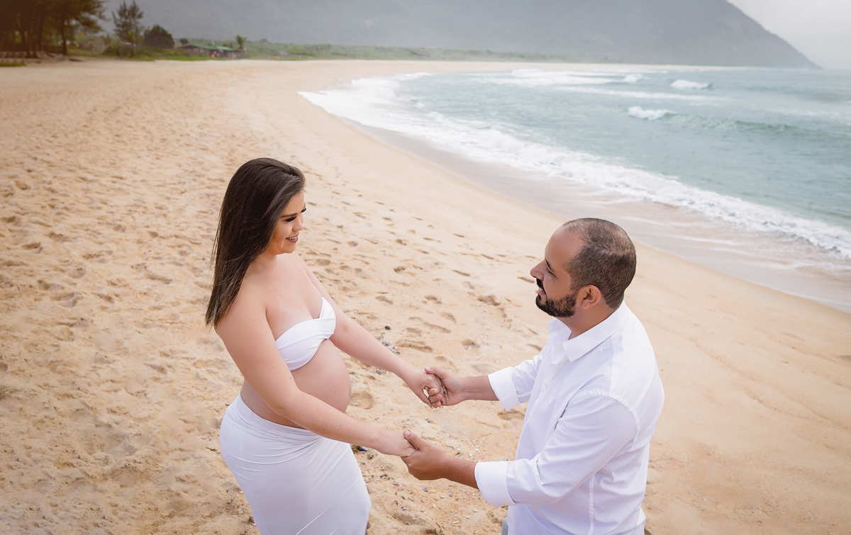 esposo segurando as mãos da gestante em ensaio na praia-rj-grumari