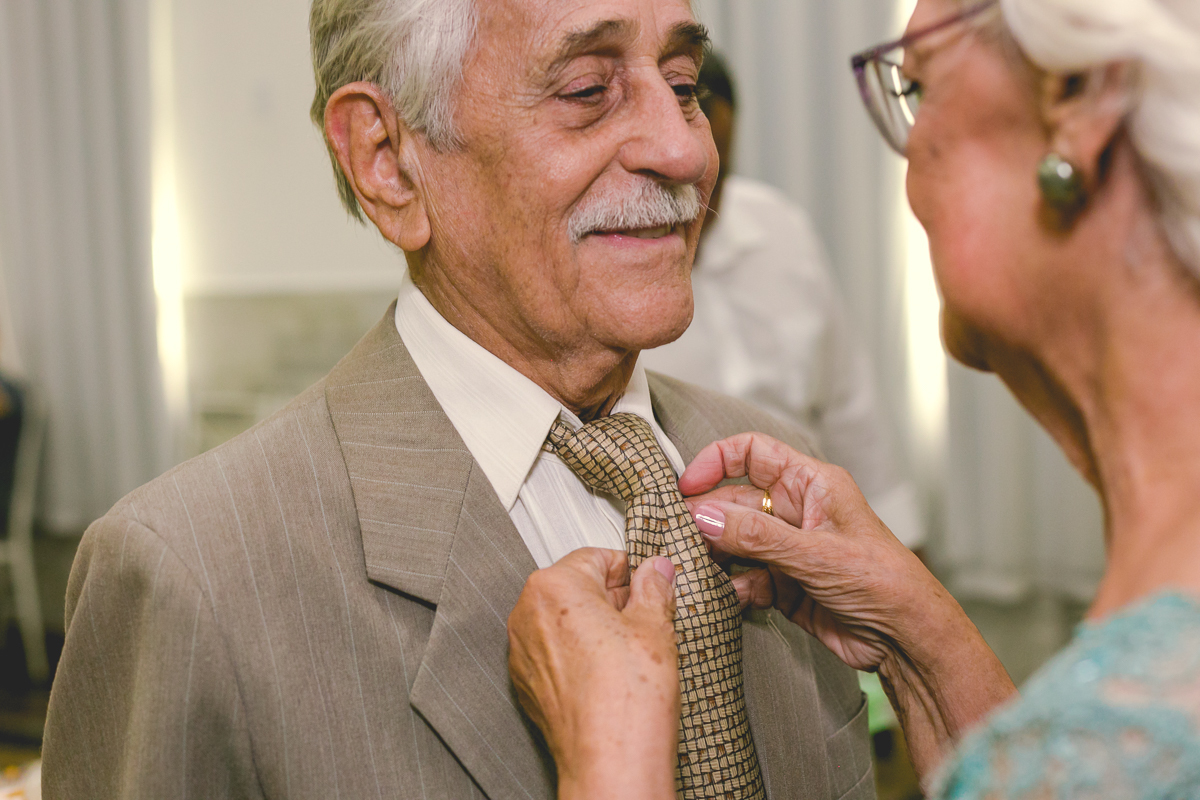 noiva ajeitando gravada do noivo em comemoração bodas de ouro/rj
