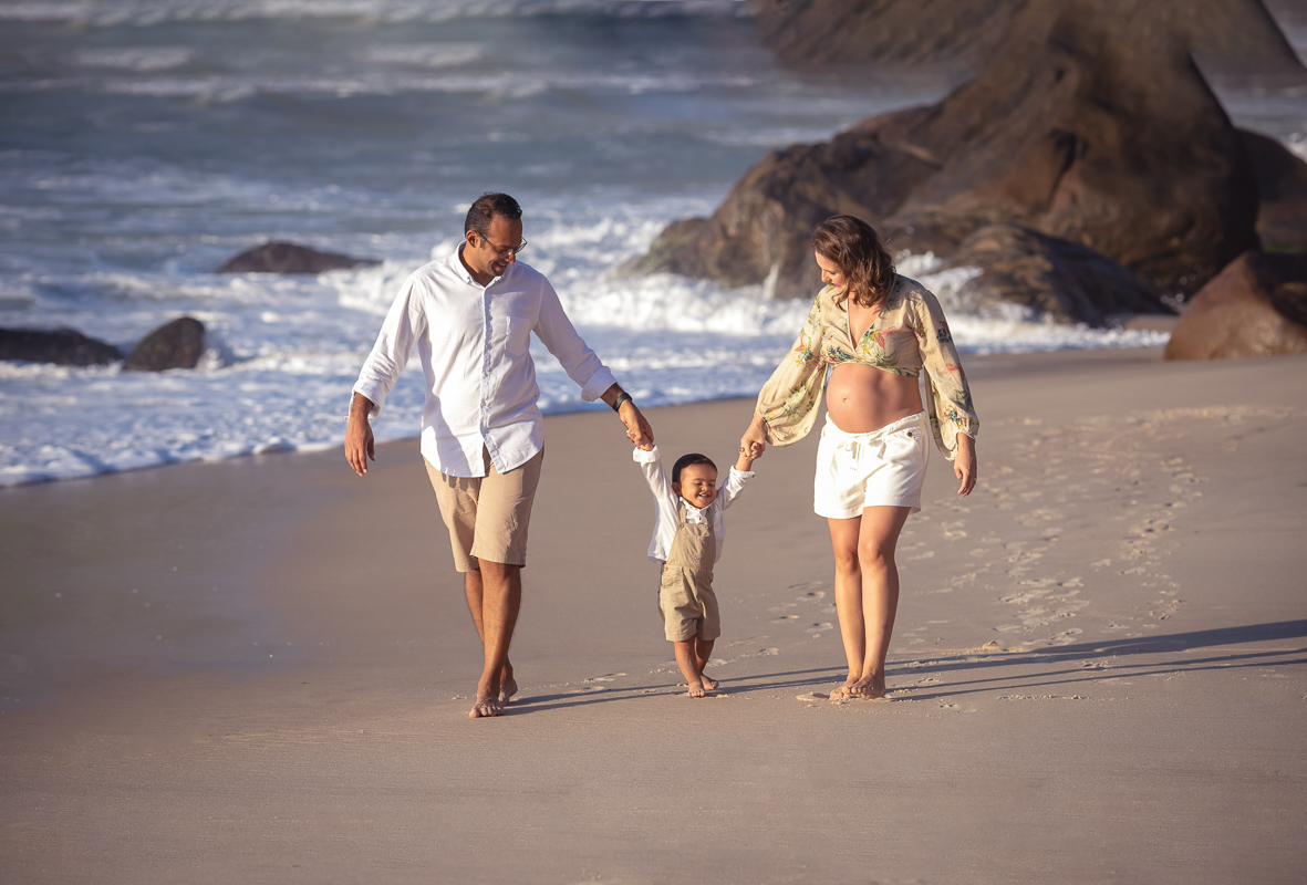 gestante caminhando com esposo e seu filho primogênito 