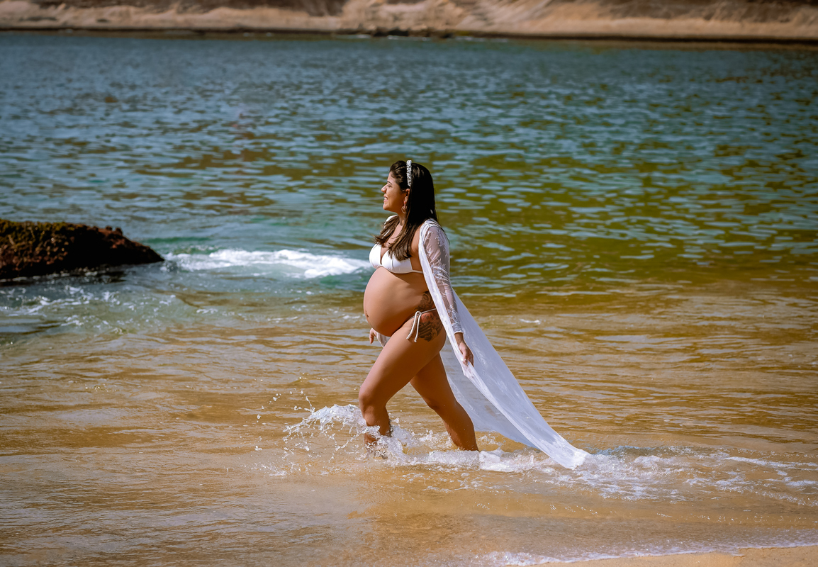 gestante caminhando  na praia em seu ensaio fotográfico externo-praia da Urca-praia vermelha-rj