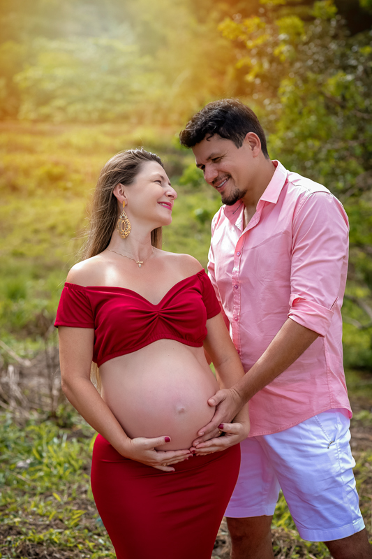 esposo posando junto em ensaio fotográfico de sua esposa gestante ele segura sua barriga e sorri-Mangaratiba-Sahy-RJ