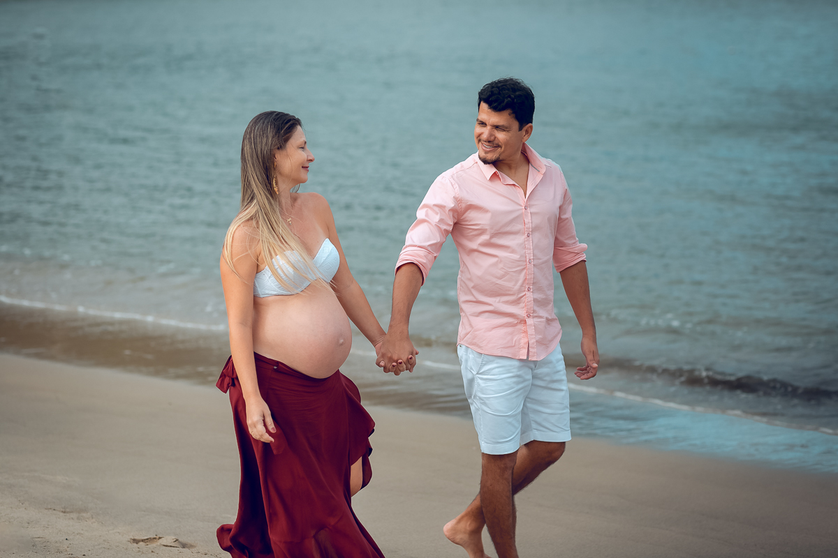 gestante caminha de mãos dados com seu esposo em ensaio book fotografico externo-praia do sahy-mangaratiba-rj