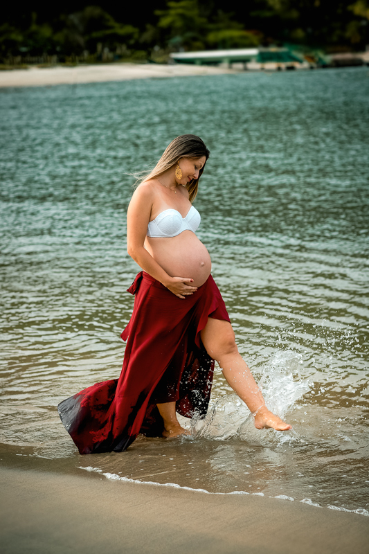 gestante caminhando na bera da praia em seu ensaio fotográfico-rj-mangaratiba-rj-sahy