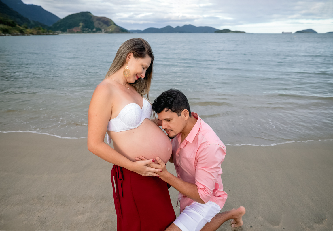 esposa de joelhos beijando a barriga da gestante em ensaio gestacional-rj-mangaratiba-sahy