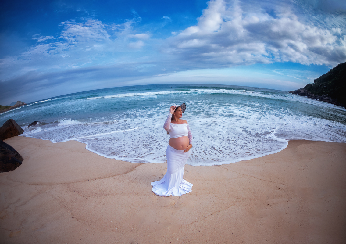 gestante fazendo pose ao fundo mar em prainha-rj