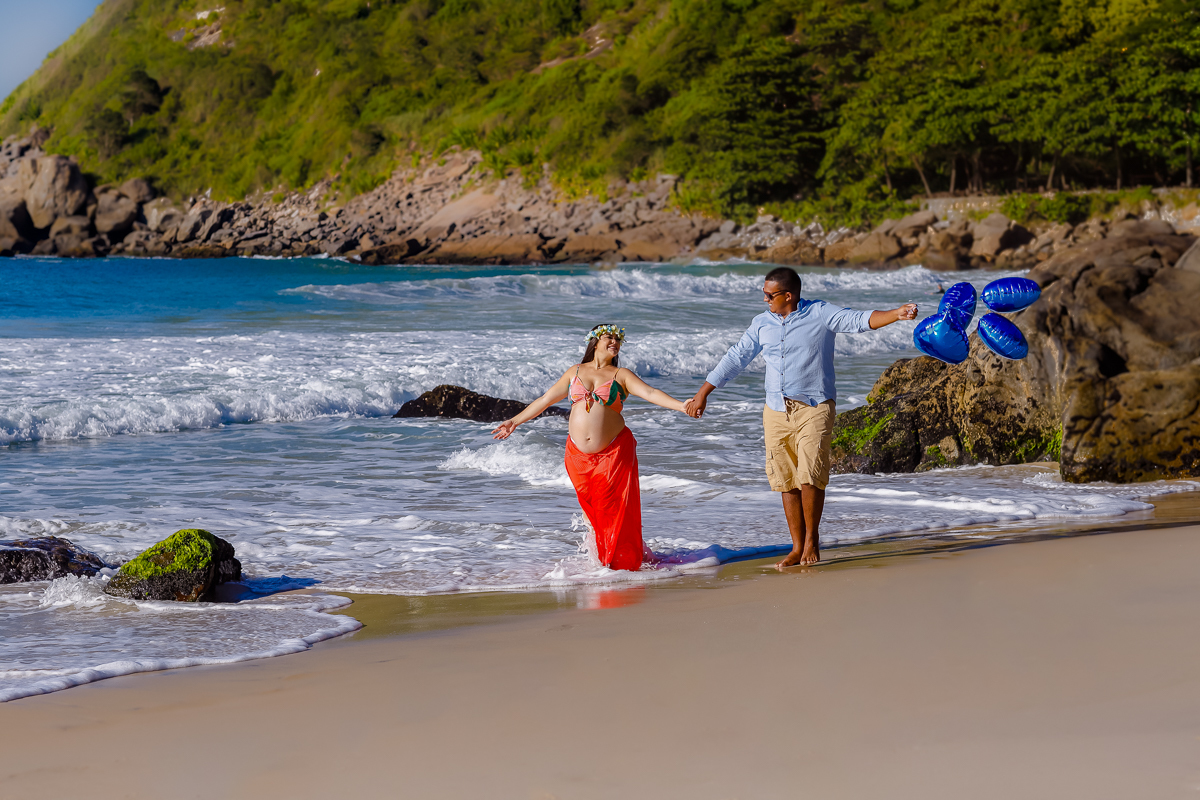 gestante caminhando de mãos dadas na praia-ensaio fotográfico externo-praias rj