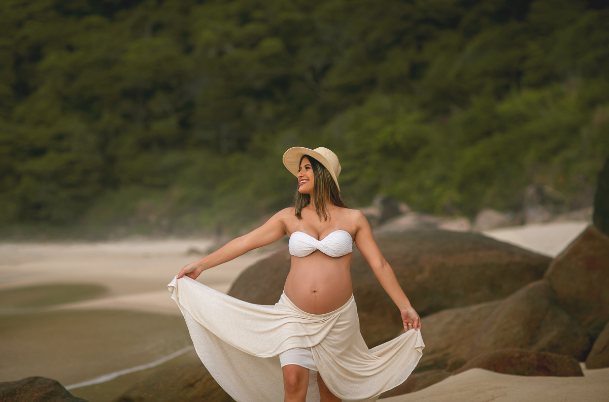 fotografia de gestante, ela caminhado na praia em seu ensaio fotográfico-externo