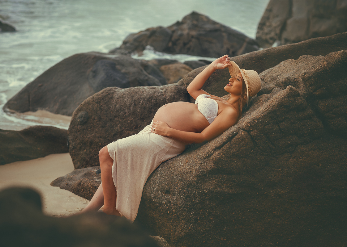 gestante deitada na pedra em seu ensaio externo na prainha-rj