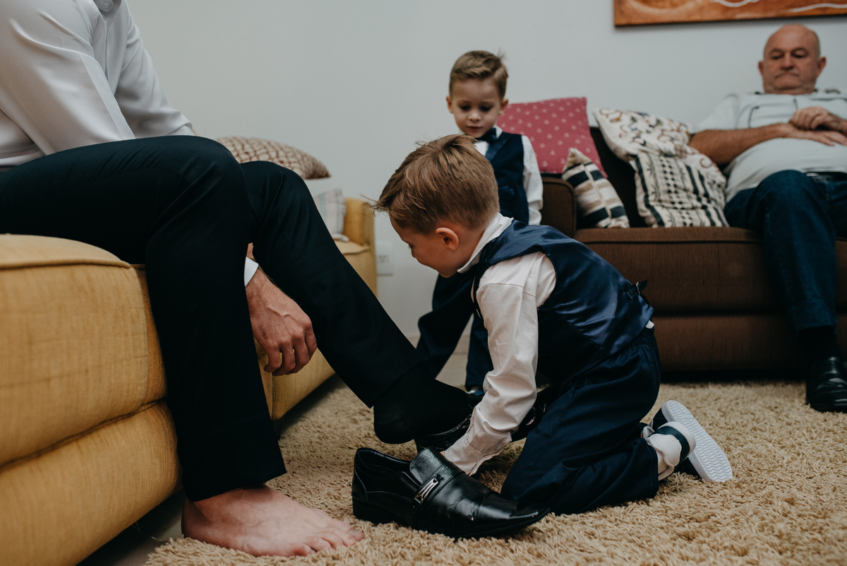 Sobrinho colocando sapato no noivo