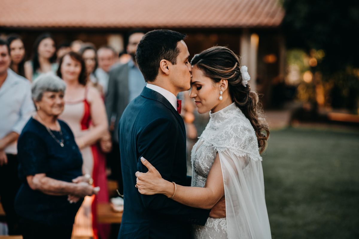 Noivo beijando a testa da noiva
